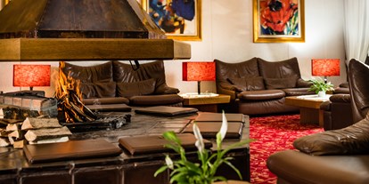 Hotels an der Piste - Dolomiten - Sitzbereich mit offenem Kamin in der Hotellobby - Sporthotel Obereggen