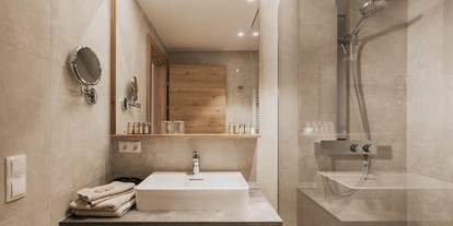 Hotels an der Piste - Hallenbad - Radstadt - Badezimmer im Doppelzimmer Deluxe - FIRSTpeak Zauchensee