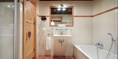 Hotels an der Piste - Sauna - Gosau - Badezimmer en suite mit Dusche, Badewanne, WC, Haarfön, Kosmetikspiegel - Almdorf Flachau
