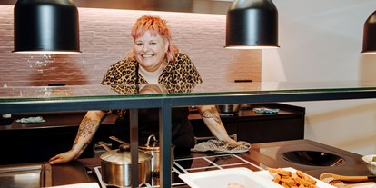 Hotels an der Piste - Sauna - Damüls - Küchenchefin und Bio-Spitzenköchin Nina Meyer in Ihrer rosa Show-Küche - Bio-Berghotel Ifenblick