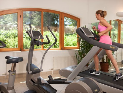 Hotels an der Piste - Wellnessbereich - Workout im lichtdurchfluteten Fitnessraum mit Technogym-Geräten  - Defereggental Hotel & Resort