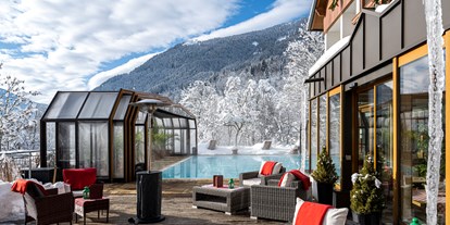 Hotels an der Piste - Hallenbad - Kärnten - Beheizter & Überdachbarer Außenpool (Winter 31°C) und Blick auf unsere Sonnenterrasse  - Genusshotel Almrausch