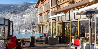 Hotels an der Piste - Skiraum: vorhanden - Kanzelhöhe - Beheizter & Überdachbarer Außenpool (Winter 31°C) und Blick auf unsere Sonnenterrasse  - Genusshotel Almrausch