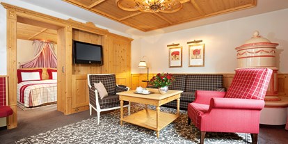 Hotels an der Piste - Skiservice: Skireparatur - Riezlern - Residieren in der exklusiven Romantik Suite mit gemütlicher Sitzecke und Kachelofen - Romantik Hotel Die Krone von Lech