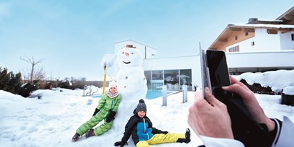 Hotels an der Piste - Ladestation Elektroauto - Mittersill - Spaß im Schnee auf der Hotelterrasse - amiamo - Familotel Zell am See