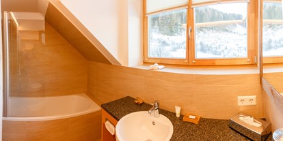 Hotels an der Piste - Sonnenterrasse - Kanzelhöhe - Badezimmer mit Badwanne - Trattlers Hof-Chalets