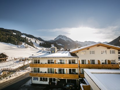 Hotels an der Piste - Langlaufloipe - Außenansicht im Winter mit Piste im Hintergrund - Familienhotel Botenwirt ***S