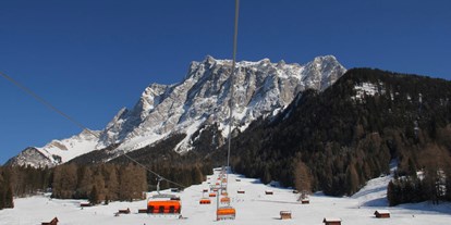 Hotels an der Piste - Après Ski im Skigebiet: Schirmbar - Sunracer 6er-Sesselbahn mit Zugspitzmassiv - Skigebiet Ehrwalder Wettersteinbahnen