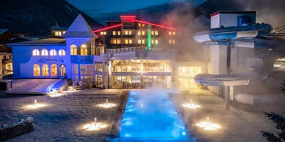 Hotels an der Piste - Ski-In Ski-Out - Enkerbichl - Außenansicht Schlosshotel Lacknerhof Winter Abend beheizter Outdoor Pool - Schlosshotel Lacknerhof****S Flachau