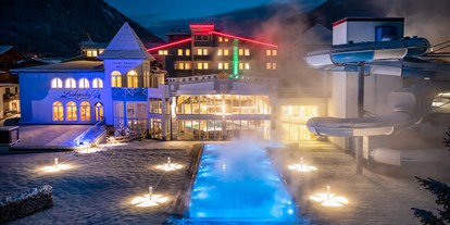 Hotels an der Piste - Skiraum: Skispinde - Großarl - Außenansicht Schlosshotel Lacknerhof Winter Abend beheizter Outdoor Pool - Schlosshotel Lacknerhof****S Flachau
