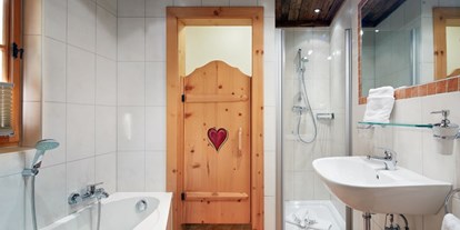 Hotels an der Piste - Sauna - Rußbachsaag - Badezimmer en suite mit Dusche, Badewanne, WC, Haarfön, Kosmetikspiegel - Almdorf Flachau