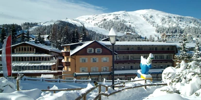 Hotels an der Piste - Skikurs direkt beim Hotel: für Kinder - Krakauschatten - Außenansicht im Winter - Familienhotel Hinteregger