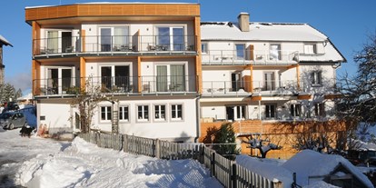 Hotels an der Piste - Ski-In Ski-Out - Gartenansicht im Winter - Familienhotel Berger ***superior