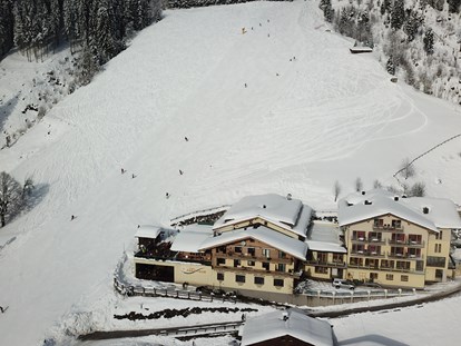 Hotels an der Piste - Wellnessbereich - Skigebiet Schmittenhöhe - Hotelansicht mit Skipiste
 - Berghotel Jaga-Alm