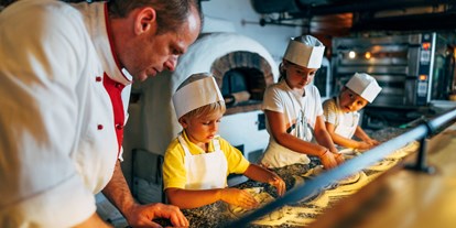 Hotels an der Piste - Wellnessbereich - Pizzabackkurs für Kinder im Hüttenrestaurant Trattlers Einkehr - Hotel GUT Trattlerhof & Chalets****