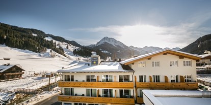 Hotels an der Piste - Hotel-Schwerpunkt: Skifahren & Tourengehen - Außenansicht im Winter mit Piste im Hintergrund - Familienhotel Botenwirt ***S