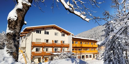Hotels an der Piste - Ladestation Elektroauto - Shuttleberg Flachauwinkl - Kleinarl - Außenansicht im Winter - Familienhotel Botenwirt ***S