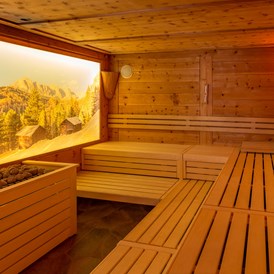 Skihotel: Finnische Zirbensauna (90° C) bzw. Kräutersauna (55°C)
16 m² große Sauna bestehend aus Natursteinplatten und naturbelassenem heimischem Zirbenholz.

Finnish Pinewood Sauna (90° C) & Herbal-Sauna (55°C)
The 16 m² sauna is made of local pinewood and natural stone slabs.

Sauna in Cirmolo (90 °C) e Sauna alle Erbe (55°C)
La sauna finlandese di 16 m² é fatta di legno di cirmolo locale e lastre di pietra naturale. - Hotel Jägerheim