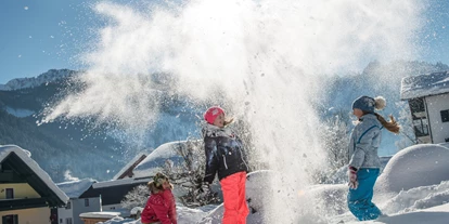 Hotels an der Piste - Verpflegung: Frühstück - Oberösterreich - spielen im Schnee im Garten vom Familienhotel Sommerhof in Gosau - Familienhotel Sommerhof