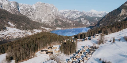 Hotels an der Piste - Skiverleih - Das Narzissendorf Zloam, im Vordergrund die Reitanlage und hinter dem Dorf mit Skihang der Grundlsee mit Berpanorama - Narzissendorf Zloam