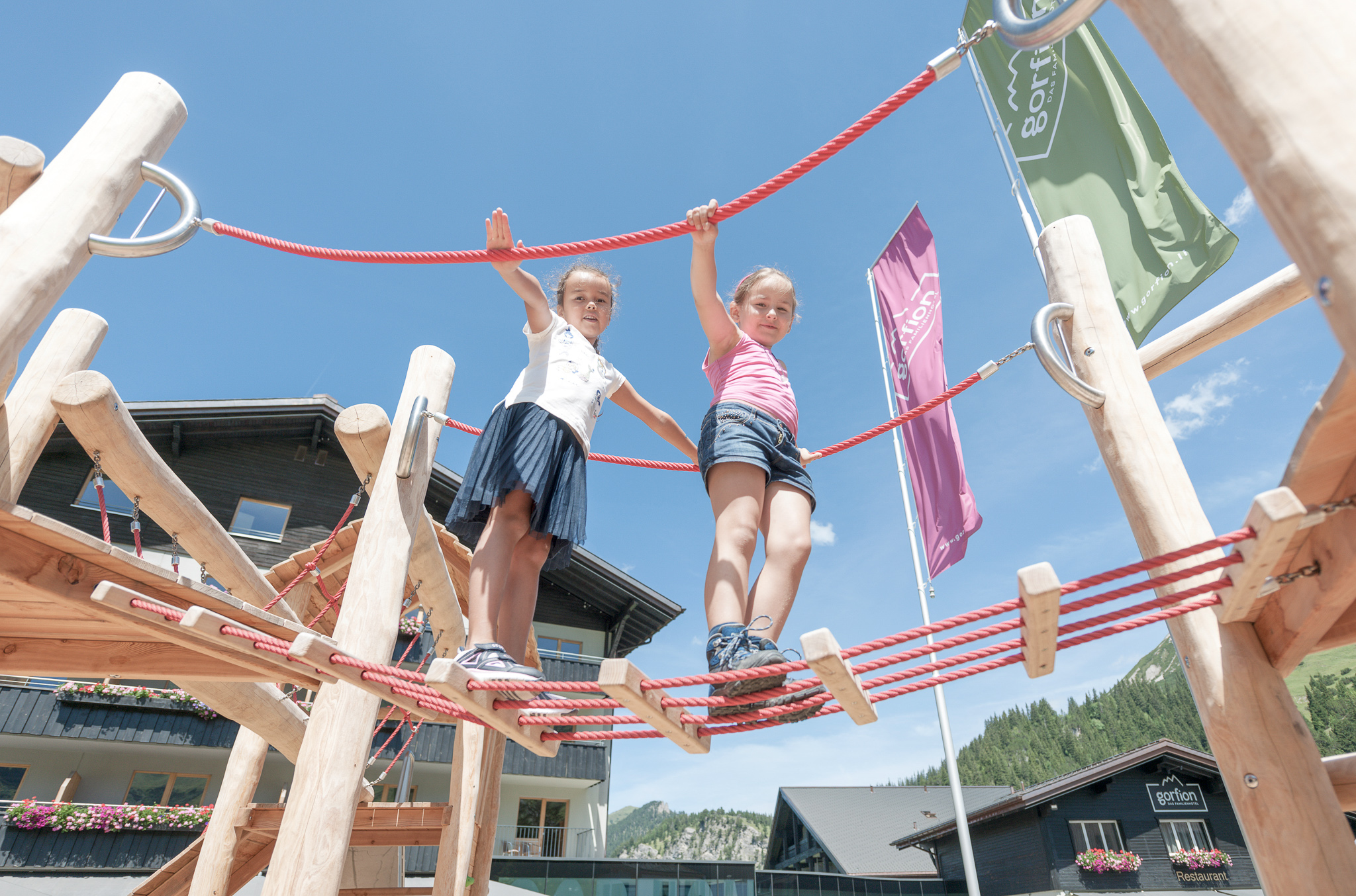 Skihotel: Outdoor-Spielplatz
Spielwiese direkt am Hotel mit Rutsche, Wippe, Schaukel und Sandkasten mit Sonnensegel
Klettergerüst
Traktorreifen Hindernisse
Fahrzeuge und Bälle zum Spielen
Mini-Kartbahn mit Fahrzeugen
Bodentrampoline
Fussballtore im Garten (Sommer)
Tischtennis-Tisch im Aussenbereich der Kaminbar (Sommer)
Sitzgelegenheiten für Eltern mit Aussicht auf die Berge - Gorfion Familienhotel Liechtenstein