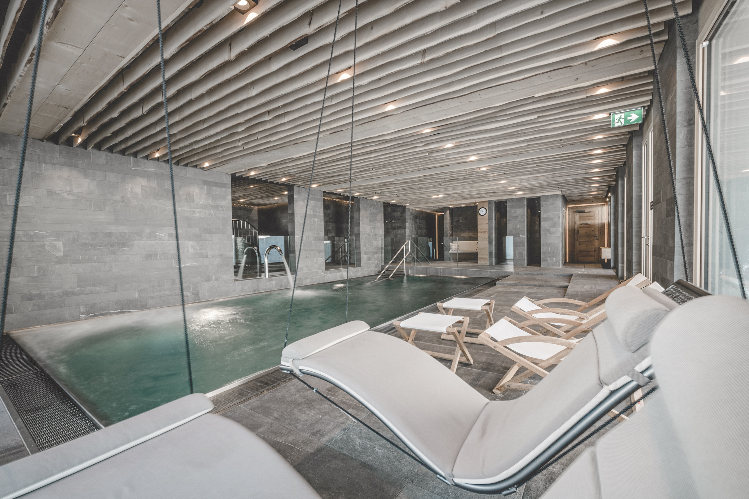 Skihotel: Indoor BergRelaxPool 1600 mit 32°C warmen Wasser, Gegenstromanlage, Blubberblasen und erfrischendem Wasserfall. Hier finden auch unsere Schwimmkurse statt. - Gorfion Familienhotel Liechtenstein - Wellness | Spa