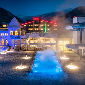 Skihotel: Außenansicht Schlosshotel Lacknerhof Winter Abend beheizter Outdoor Pool - Schlosshotel Lacknerhof****S Flachau