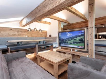 Hotels an der Piste - PLZ 6373 (Österreich) - Frisch renoviert: Der brandneue Aufenthaltsraum der "Galerie" mit großem Esstisch, Bar, drehbarem TV und luxuriöser Küche mit Natursteinplatte - Ferienwohnungen Perfeldhof