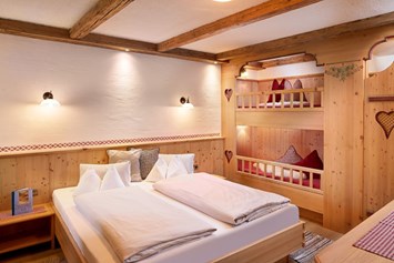 Skihotel: Schlafzimmer mit Doppelbett und Stockbett - Almdorf Flachau
