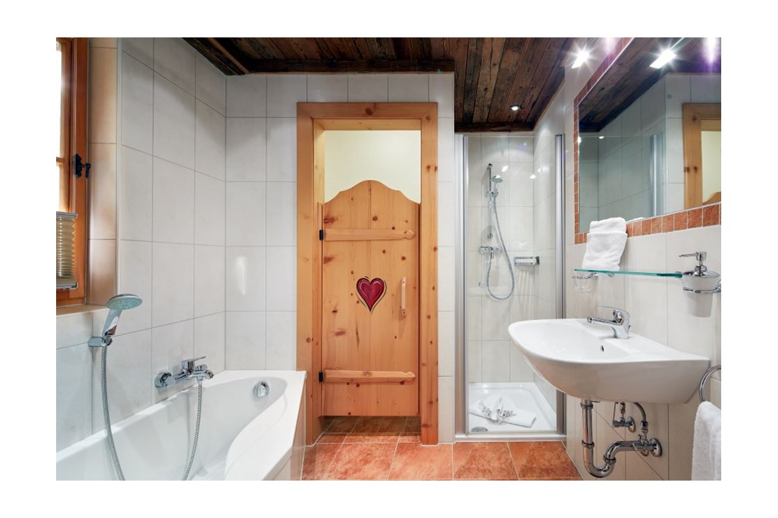 Skihotel: Badezimmer en suite mit Dusche, Badewanne, WC, Haarfön, Kosmetikspiegel - Almdorf Flachau