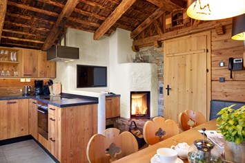 Skihotel: Großer Esstisch mit offenem Kamin - Promi Alm Flachau