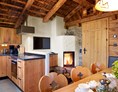 Skihotel: Großer Esstisch mit offenem Kamin - Promi Alm Flachau