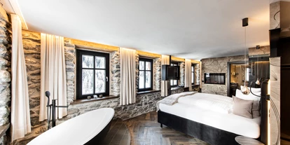 Hotels an der Piste - Sauna - Kappl (Kappl) - Wellness Suite - Charaktervolles, grosses Zimmer mit Natur-Steinwänden, freistehender Badewanne und privater Infrarot-Kabine.
Bettengrösse (LxBxH): 200 x 180 x 73cm
Zimmergrösse: 40m2
Ausgestattet mit Walk-in Regendusche, Doppelwaschbecken aus Naturstein, Holzboden in Fischgrätverlegung, WC, Flatscreen-HDTV und -Radio, Zimmersafe, Effektfeuer, WLan.
Im Badezimmer finden Sie einen Haartrockner, flauschige Frotteewäsche, Pflegeprodukte und weitere Hygieneartikel. Bademäntel für den Besuch unseres hauseigenen Wellnessbereichs.
Halbpension im Zimmerpreis inkludiert:
Frühstücksbuffet mit Spezialitäten aus der Samnauner Sennerei und frischgekochten Eierspeisen.
5-Gang Wahl Abendmenu mit hausgemachtem, ofenfrischem Brot zum Einstieg.
Garagenplatz im Zimmerpreis inkludiert.
Nichtraucherzimmer. Keine Zusatzbetten. Kein Balkon. Keine Haustiere. - LARET private Boutique Hotel | Adults only