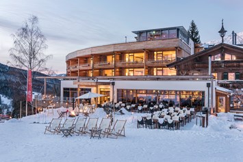 Skihotel: Sonnenterrasse mit Sundowner, DJ und gemütliche Winteratmosphäre - Holzhotel Forsthofalm