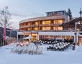 Skihotel: Sonnenterrasse mit Sundowner, DJ und gemütliche Winteratmosphäre - Holzhotel Forsthofalm