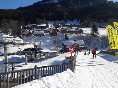 Hotels an der Piste - Skikurs direkt beim Hotel: für Kinder - Blick in Richtung Loser, Skibrücke, Skiarena. Links oben ein Teil der Hagan Loges, direkt an der Loser-Piste. - AlpenParks Aktiv & Natur Resort Hagan Lodge Altaussee