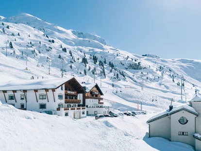 Hotels an der Piste - Mellau - Lage im Winter - an der Sonnenseite von Zürs, direkt an der Skipiste - Hotel Enzian