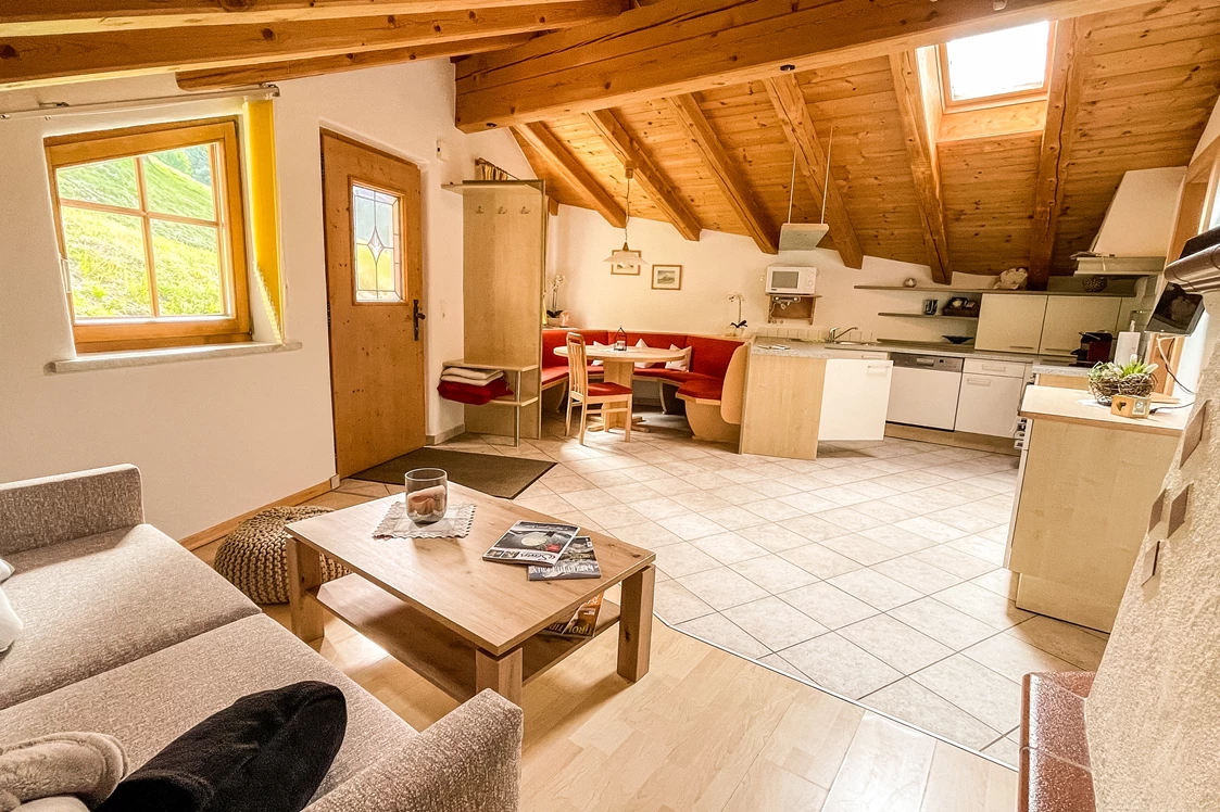 Skihotel: Wohnraum mit bestens eingerichteter Küchenzeile, Essbereich und Doppelschlafcouch - Ferienwohnung Tenn - Ferienwohnung Tenn