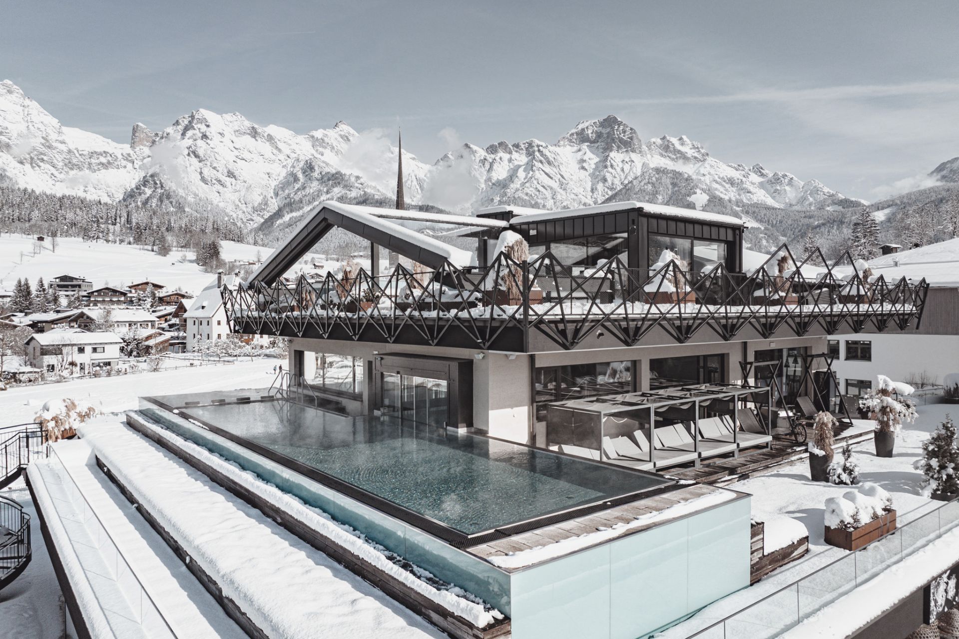 Hotels an der Piste - Beheizter Infinity-Outdoor-Pool im Wellnesshotel die HOCHKÖNIGIN in Maria Alm am Hochkönig mit Blick auf das verschneite Steinerne Meer. - die HOCHKÖNIGIN - Mountain Resort