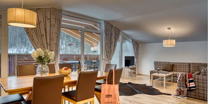 Hotels an der Piste - Verpflegung: Halbpension - Itter - Wohn- und Essbereich im Apartment - COOEE alpin Hotel Kitzbüheler Alpen