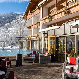 Skihotel: Beheizter & Überdachbarer Außenpool (Winter 31°C) und Blick auf unsere Sonnenterrasse  - Genusshotel Almrausch