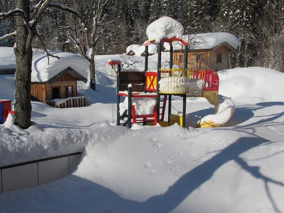 Skihotel: Unser Spielplatz am Haus - tief verschneit - Familienhotel Unterreith