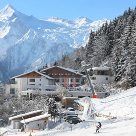 Skihotel: Hotelansicht Winter - direkt an der Piste - amiamo - Familotel Zell am See