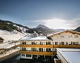 Skihotel: Außenansicht im Winter mit Piste im Hintergrund - Familienhotel Botenwirt ***S