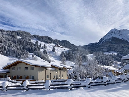 Hotels an der Piste - Ramsau am Dachstein - Außenansicht von der Loipe aus mit Champion Shuttle und Piste im Hintergrund - Familienhotel Botenwirt ***S